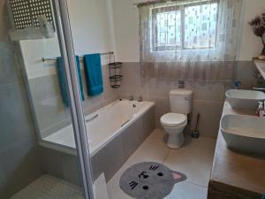 a bathroom with a tub and a toilet and a sink at Omidraai Opihoek in Boknes