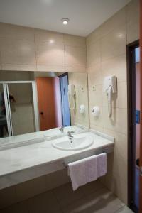 a bathroom with a sink and a mirror at Hostal Mediterranea in Madrid