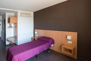 1 dormitorio con cama morada y mesa en Hostal Mediterranea en Madrid