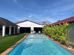 a swimming pool in the backyard of a house at Sanyan Retreat in Jeram