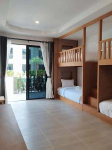 a bedroom with two bunk beds and a balcony at Double Rock Beach Hotel in Thong Sala