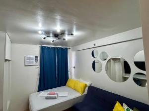 a small room with a bed and a blue curtain at Unit 26 SeaView Studio in Dumaguete