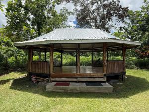a gazebo with a metal roof on the grass at Secure Vailima Home with Fale in Apia