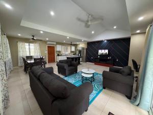 a living room with two couches and a dining room at Secure Vailima Home with Fale in Apia