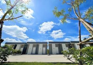 a large white building with a blue sky in the background at โรงแรมหลังสวนเพลส Langsuan place Hotel in Lang Suan