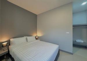 a bedroom with a white bed and a window at โรงแรมหลังสวนเพลส Langsuan place Hotel in Lang Suan