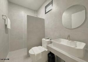 a bathroom with a sink and a toilet and a mirror at โรงแรมหลังสวนเพลส Langsuan place Hotel in Lang Suan