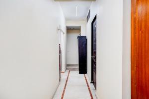 a hallway with white walls and a red and white floor at FabHotel Sarala Residency in Noida +22 photos