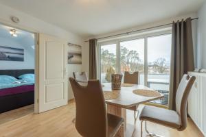 a room with a table and chairs and a bedroom at Fewo Lebensart - in bester Lage, mit TG und Balkon in Baabe