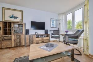 a living room with a tv and a table at Fewo Meeresleuchten - Strandkorb auf Balkon, TG in Baabe