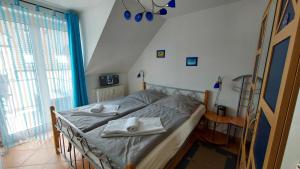 a bedroom with a bed with two towels on it at Fewo Meeresleuchten - Strandkorb auf Balkon, TG in Baabe