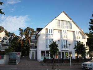 a white house with a car parked in front of it at Fewo Meeresleuchten - Strandkorb auf Balkon, TG in Baabe