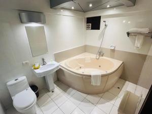 a bathroom with a tub and a toilet and a sink at Royal Garden Hotel in Lima