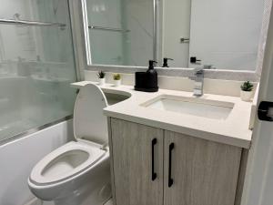a bathroom with a toilet and a sink and a mirror at Comfort 2 BR Vancouver! in Vancouver