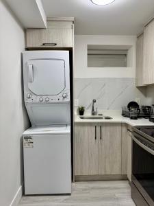 a kitchen with a white refrigerator and a sink at Comfort 2 BR Vancouver! in Vancouver +3 photos