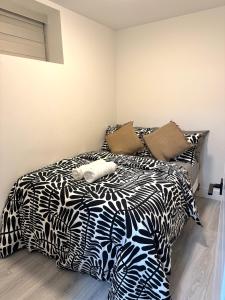 a bed with black and white sheets and pillows at Comfort 2 BR Vancouver! in Vancouver