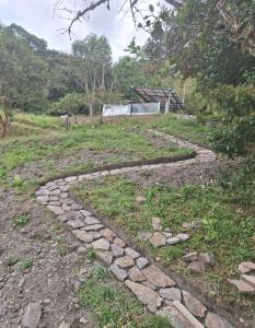 a stone path in a field with a building in the background at Manawa Kaona in Somondoco