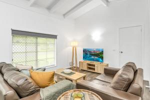 a living room with a couch and a table at Hidden Gem - 3BR Home - Cairns in Edge Hill