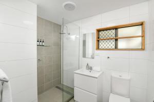 a white bathroom with a toilet and a shower at Hidden Gem - 3BR Home - Cairns in Edge Hill +72 photos