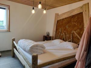 a bedroom with a wooden bed with white sheets and pillows at Appartement Terrasse Jacuzzi du Pont Alsort 2-2 in Froid-Chapelle