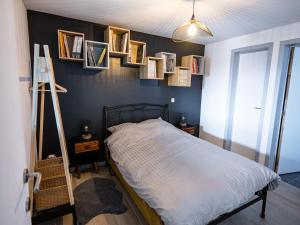 a bedroom with a bed with framed pictures on the wall at Appartement Spa VIP du Pont Alsort 2-3 in Froid-Chapelle