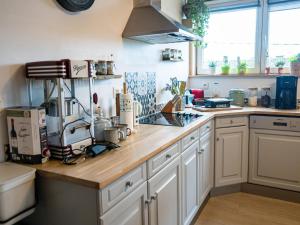 a kitchen with white cabinets and a wooden counter top at Appartement Spa VIP du Pont Alsort 2-3 in Froid-Chapelle