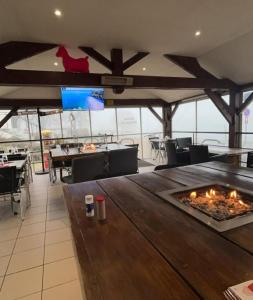 a restaurant with a fireplace in the middle of a room at CAMPING LES HERLEQUINS in Losne