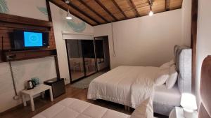 a bedroom with a bed and a flat screen tv at Manawa Kaona in Somondoco