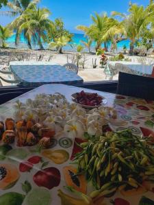 a table with fruits and vegetables on it on the beach at MONITA VILLA Rangiroa in Tiputa