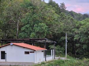 a small white building with a metal roof at Manawa Kaona in Somondoco