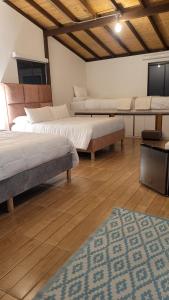 a room with two beds and a rug at Manawa Kaona in Somondoco