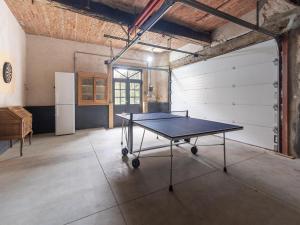 a ping pong table in a room with a garage at Scenic villa in Borgloon with garden in Borgloon
