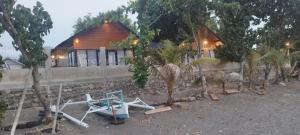 a boat sitting on the ground in front of a house at Oreo Beach Villa Kayangan in Luhuk