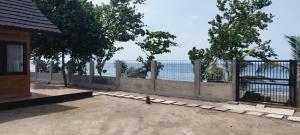 a bird sitting on the ground next to a fence at Oreo Beach Villa Kayangan in Luhuk +3 photos