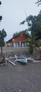 a boat sitting on the ground in front of a house at Oreo Beach Villa Kayangan in Luhuk