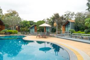 a swimming pool in front of a house at The Tree Riverside Resort Kaeng Krachan in Kaeng Krachan