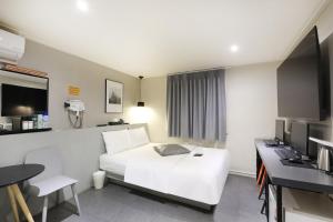 a hotel room with a white bed and a desk at Hotel Yam Bucheon Station in Bucheon