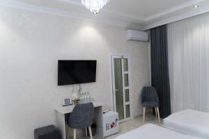 a hotel room with a bed and a tv on the wall at Afruza Hotel in Samarkand