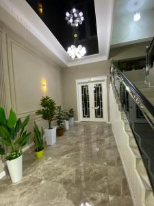 a lobby with potted plants and a staircase at Afruza Hotel in Samarkand