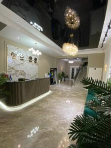 a lobby with chandeliers and plants in a building at Afruza Hotel in Samarkand