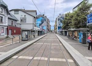 an empty street with train tracks in a city at Studio Cosy - Proche Tram et Gare de Grenoble in Fontaine +2 photos