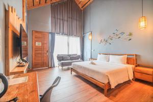 a bedroom with a large bed and a couch at The Tree Riverside Resort Kaeng Krachan in Kaeng Krachan
