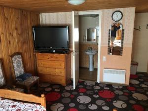 ein Wohnzimmer mit einem Flachbild-TV und ein Schlafzimmer in der Unterkunft Tolli Hostel & Holiday House in Valga