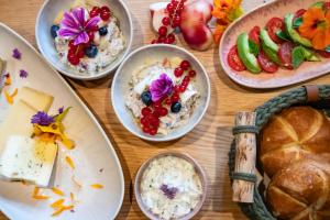 a wooden table with plates of food and bread at Fannys in Weißach +13 photos