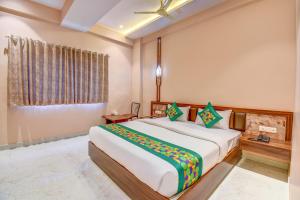a bedroom with a large bed and a window at FabHotel Ayodhya in Pune