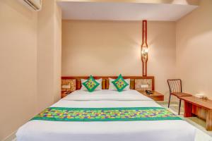 a bedroom with a bed with a desk and a table at FabHotel Ayodhya in Pune