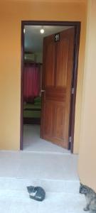 a cat laying on the floor in front of a door at Bayu Beach Chalet PCB in Kota Bharu