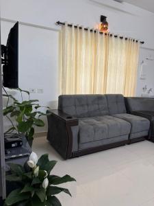 a living room with a couch and a television at DOWN TOWN HOLIDAYS Kovalam in Kovalam