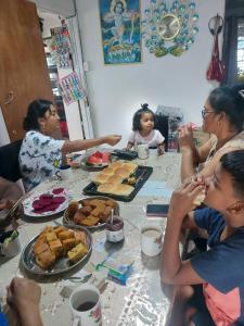 a group of people sitting around a table eating food at Ronika devi in Savu +9 photos