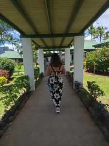 a woman is walking down a sidewalk at Ronika devi in Savu